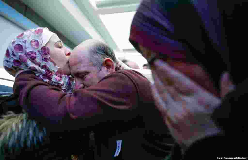Bara Haj Khalaf (levo), izbeglica iz Sirije, ljubi svog oca Khaleda dok joj majka plače nakon što su stigli na aerodrom O'Hare u Čikagu, 7. februara 2017. Oni su doputovali pošto je zabrana putovanja stanovništva iz sedam većinski muslimanskih zemalja, uključujući i Siriju, odložena zbog pravnih izazova. (Reuters/Kamil Krzaczynski) 