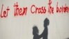 Silueta e dy fëmijëve emigrantë në Idomeni të Greqisë, reflekton në një mur ku shkruan:“Lejoni ta kalojnë kufirin”.