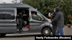 Poliția care arestează un jurnalist e fotografiată ce un corespondent Reuters chiar înainte de a fi arestat el însuși în centrul capitalei belaurse Minsk, în 27 august 2020.