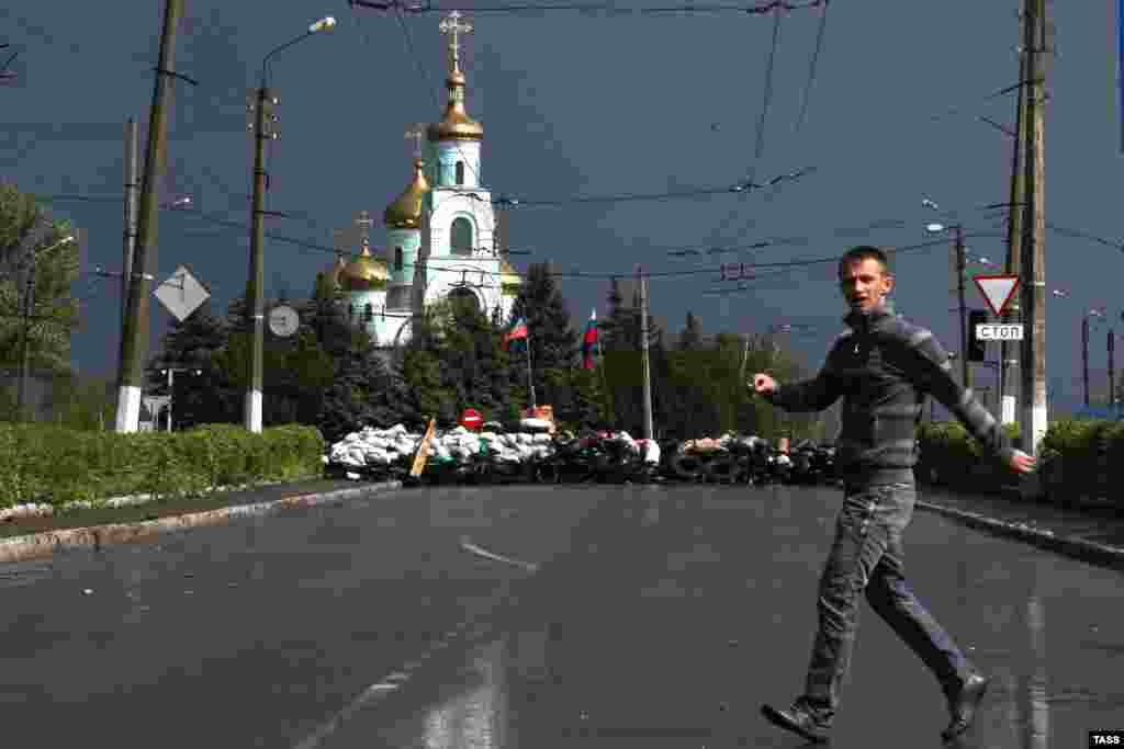 Молодий чоловік перебігає вулицю перед КПП проросійських бойовиків у центрі Слов’янська, 5 травня 2014 року