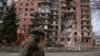 Український військовослужбовець проходить повз багатоповерхівку, пошкоджену внаслідок російських обстрілів, Покровськ, 6 березня 2025 року
