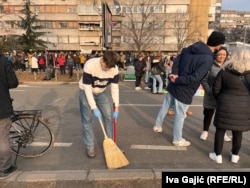 Një student pastron një rrugë që ishte e bllokuar për 27 orë gjatë protestës në Novi Sad, 2 shkurt 2025.