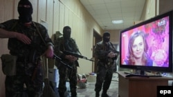Persoane înarmate pro-ruse păzesc intrarea în biroul procurorului din Lugansk, 30 aprilie 2014