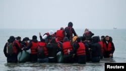 Migranti se ukrcavaju na gumeni čamac napuštajući obalu na sjeveru Francuske, 24. novembar 2021. 