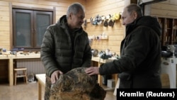 Vlagyimir Putyin (jobbra) és Szergej Sojgu egy műhelybe is ellátogatott, miközben együtt pihentek Szibériában 2021 márciusában