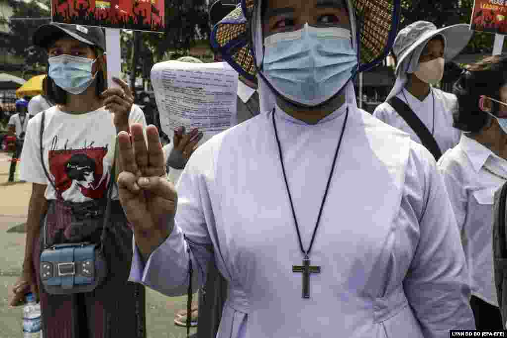 Călugărițe catolice cu pancarte în timpul unui protest împotriva puciului în fața Ambasadei Chinei în Yangon, Myanmar, 21 februarie 2021. (Foto: Lynn BO BO / EPA-EFE )