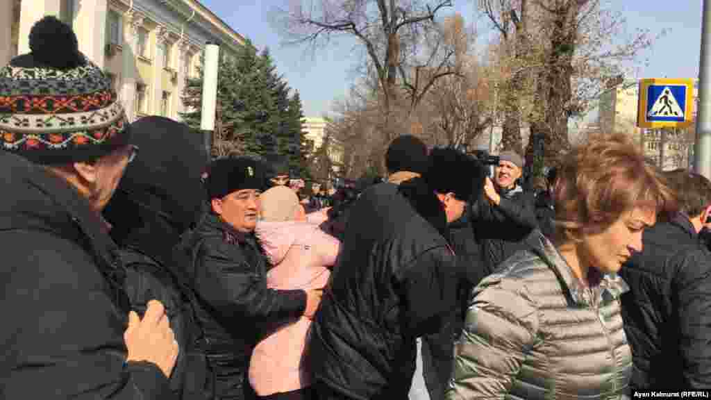Полиция кейбір азаматтарды көлікке күшпен жеткізді. 