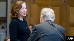 U.S. State Department legal adviser Jennifer Newstead (left), and Iranian legal representative Mohsen Mohebi talk at the International Court of Justice (ICJ) in the Hague on August 27.