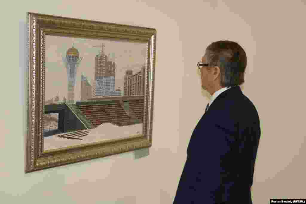Посетитель смотрит на картину Калиоллы Ахметжана «Арайлы Астана» («Озаренная Астана»).