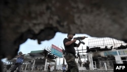 Esgerler we polisiýa işgärleri Oşdaky operasiýalarda, 21-nji iýun, 2010.