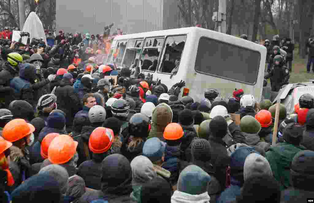 Під час протистояння на вулиці Грушевського.На фотографії розхитують міліцейський автобус. Київ, 19 січня 2014 року