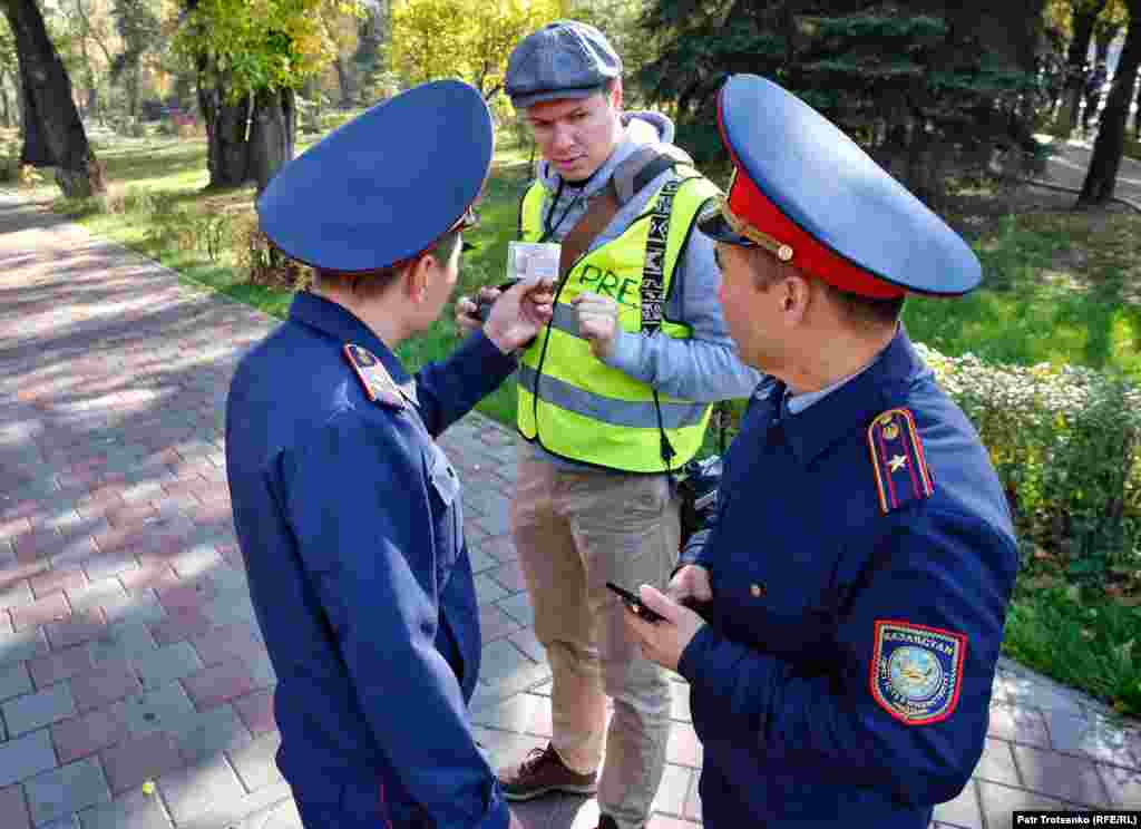 Ашық жасыл және қызғылт түсті жилет киіп, оқиғадан ақпарат таратқан журналистерге формадағылар келіп, қызметтік куәліктерін тексерді, телефондарын суретке түсіріп алды. Суретте полицейлер фототілші Владимир Третьяковтың қызметтік куәлігін тексеріп жатыр. 
