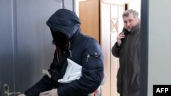 Білоруські силовики ховають обличчя під час обшуку у голови Білоруської Асоціації журналістів Андрія Бастунця. Мінськ, Білорусь. 16 лютого 2021року