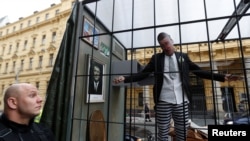 Opozanți ai politicianului au instalat o cușcă în fața Tribunalului municipal de la Praga în care stătea un bărbat cu o mască a lui Babiš pe față, 12 septembrie 2022.