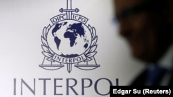 Një person kalon pranë logos së INTERPOL-it.