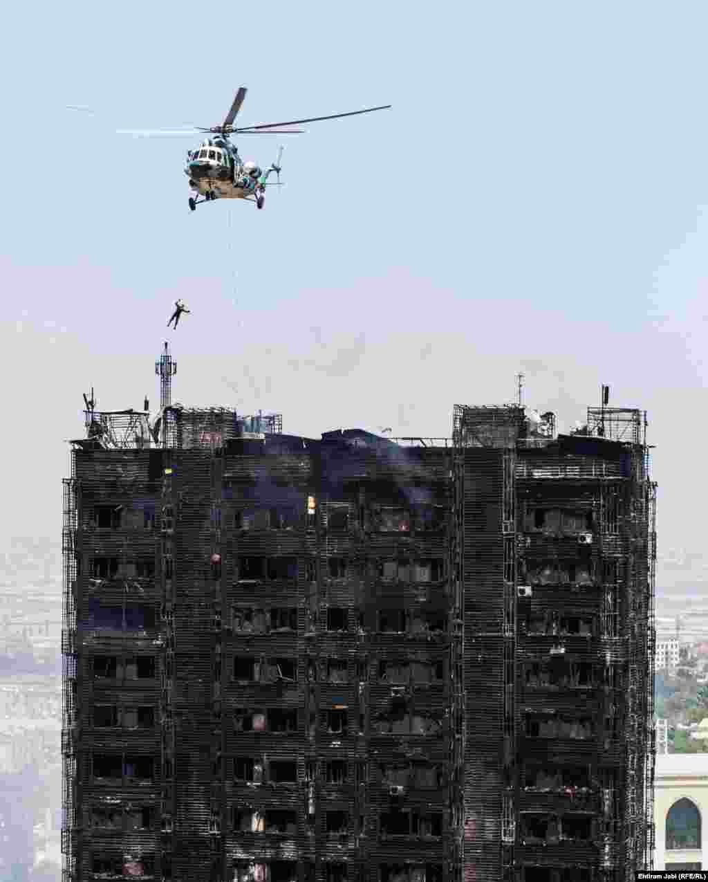 A rescue worker abseils from a helicopter during rescue attempts at a large fire in a high-rise apartment building in Baku. At least 15 people died in the blaze. (Ehtiram Jabi/RFE/RL)