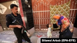په پاکستان کې یوه روغتیاپاله یو ماشوم ته د پولیو واکسیني څاڅکي ورکوي - انځور له ارشیفه.