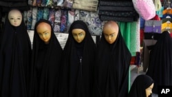 Manekine të veshura në çadore shfaqen në një dyqan në qytetin Qom, në Iran.
