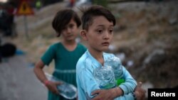 Copii din tabăra de refugiați Moria, de pe insula Lesbos după incendiul de miercuri, Grecia, 9 septembrie 2020.