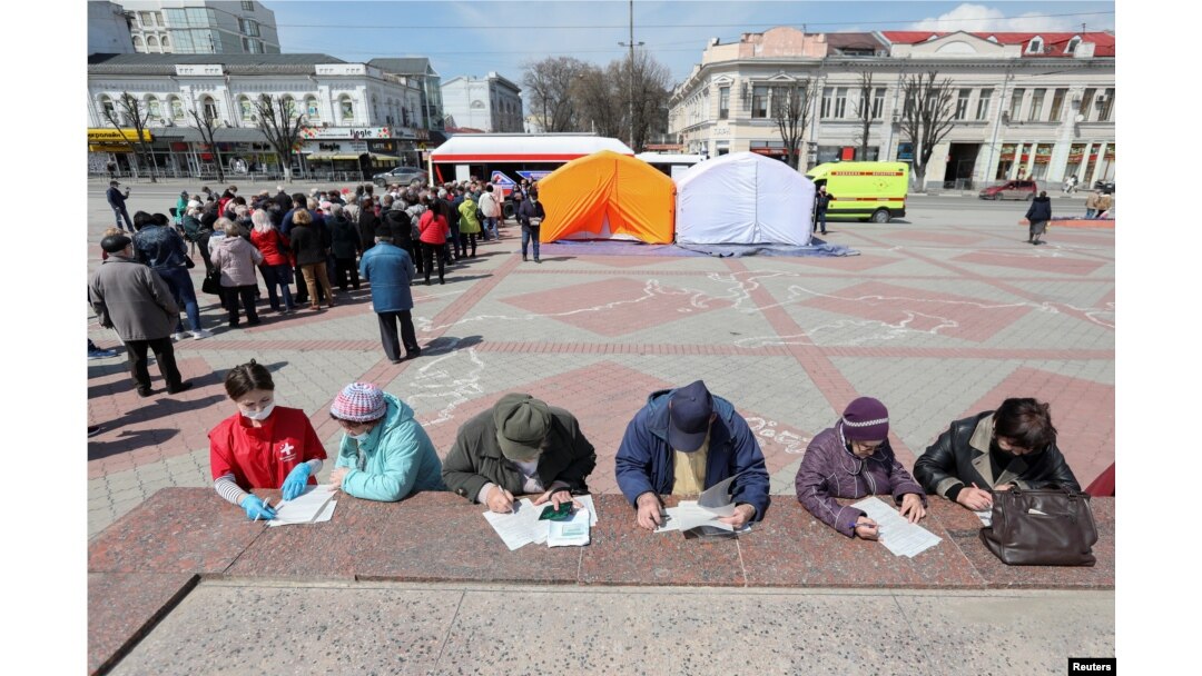 Люди ждут своей очереди на вакцинацию от коронавируса в Симферополе, городе в аннексированном Россией Крыму.