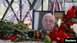 Lule të vendosura pranë fotografisë së Yevgeny Prigozhin, themeluesit të grupit të mercenarëve, Wagner. 